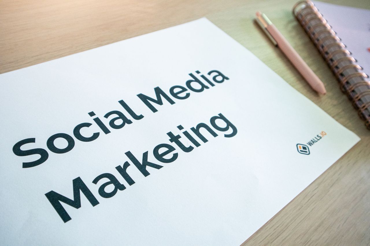 Close-up view of a social media marketing document resting on a desk beside a pen and notebook.